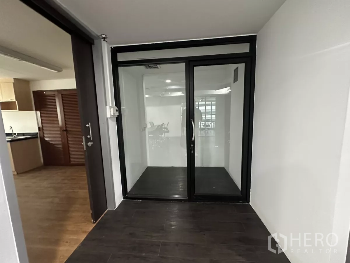 办公空间 出租在Watthana, Bangkok - 入口前厅，黑框双层玻璃门通往主工作区。