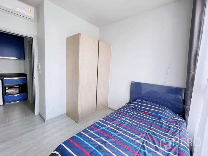 คอนโด ให้เช่าหรือขายในWatthana, Bangkok - ห้องนอนที่สอง เตียงเดี่ยว ตู้เสื้อผ้า และแสงธรรมชาติ มองไปยังมุมครัว