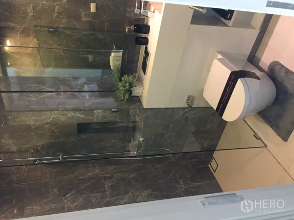公寓 出售在Bang Rak, Bangkok - 现代浴室，玻璃淋浴间、深色大理石墙面与智能马桶