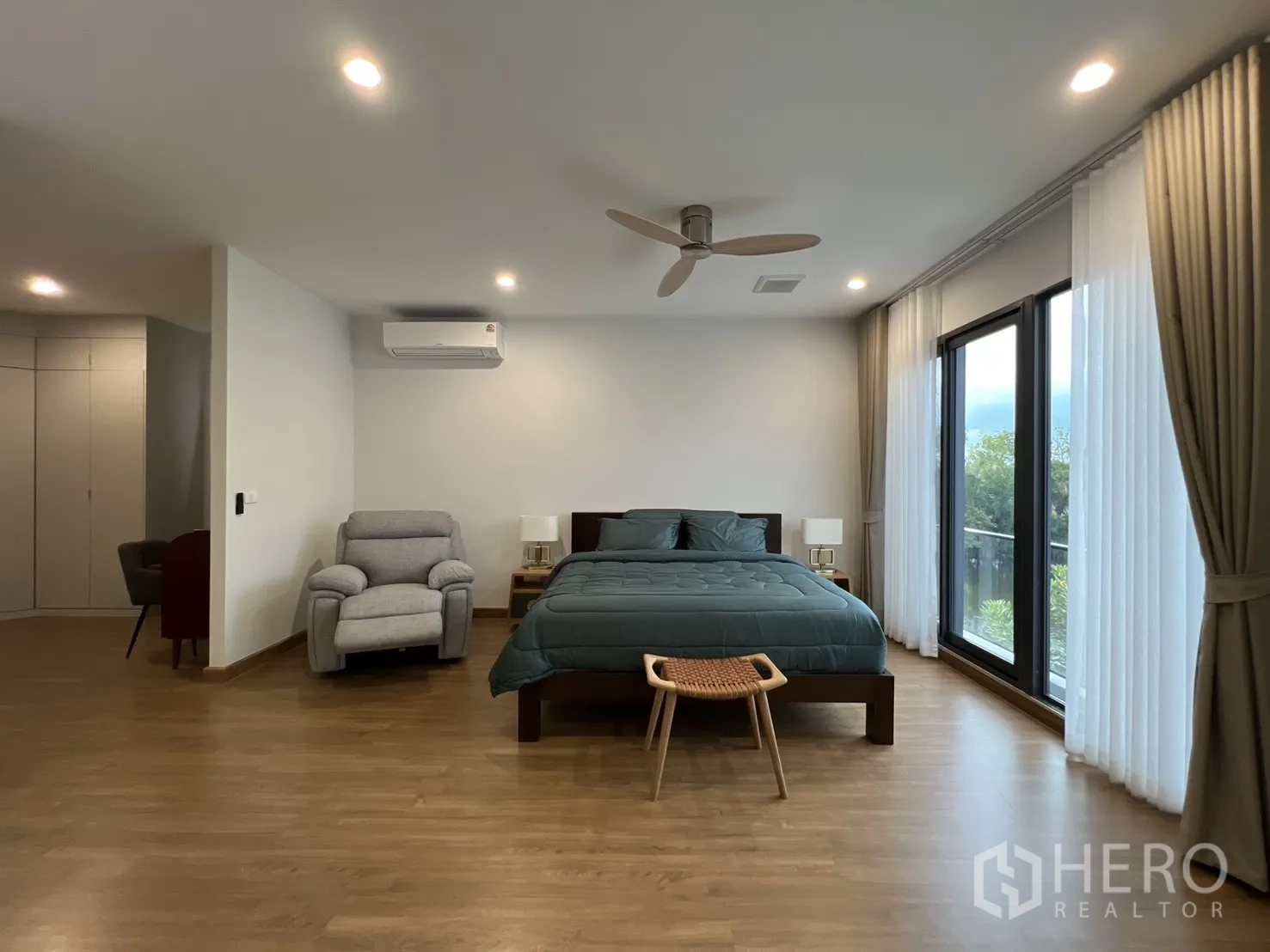 Detached House for rent in Prawet, Bangkok - Master bedroom with balcony doors and floor-to-ceiling curtains.