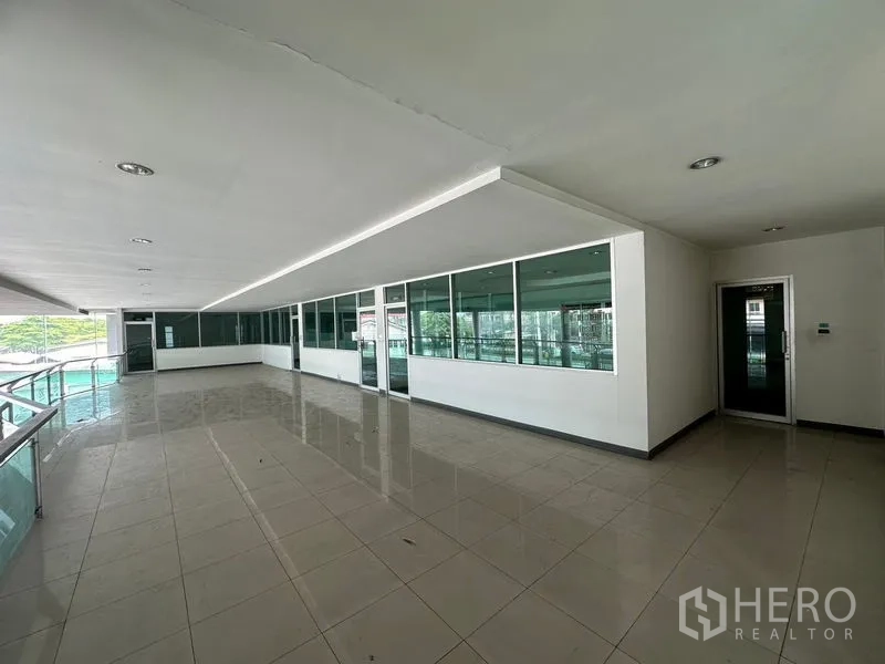 Showroom for rent or sale in Lam Luk Ka, Pathum Thani - Spacious balcony walkway with glass partitions and tiled floor.