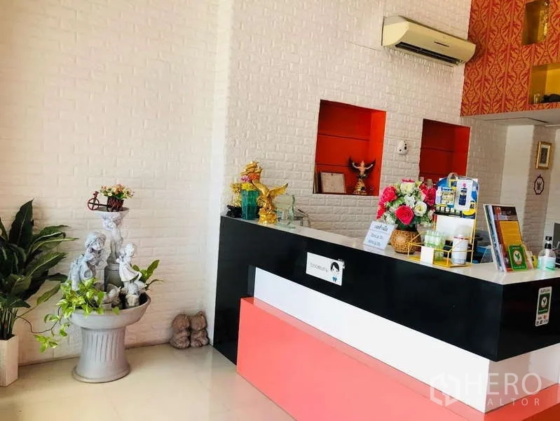 Shophouse for rent or sale in Bang Khun Thian, Bangkok - Reception area featuring a black-and-white counter, white brick wall, indoor plants and accent niches.