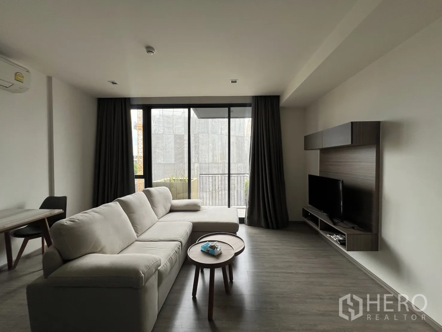 คอนโด for rent in Watthana, Bangkok - ห้องนั่งเล่นพร้อมโซฟาเข้ามุม ชุดทีวีติดผนัง และประตูบานเลื่อนเปิดสู่ระเบียง