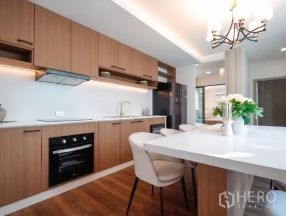 บ้าน ให้เช่าในSattahip, Chon Buri - ครัวดีไซน์เรียบหรู ตู้ไม้ยาว โต๊ะไอส์แลนด์ และโคมแชนเดอเลียร์