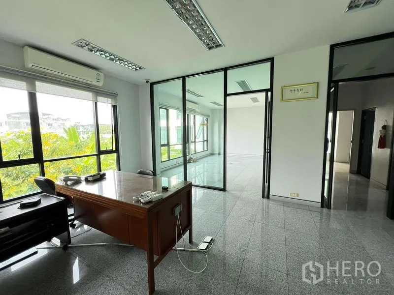Office Space for sale in Bang Na, Bangkok - Private manager’s office with desk, glass partitions and leafy outlook.