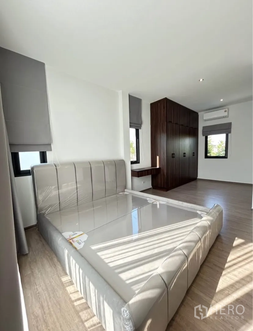 บ้านแฝด for rent in Bang Phli, Samut Prakan - ห้องนอนใหญ่กว้าง ฐานเตียงบุหนัง ตู้เสื้อผ้าบิวท์อินขนาดใหญ่ และหน้าต่างมุม