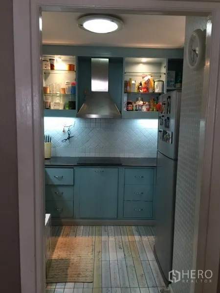 公寓 出租或出售在Watthana, Bangkok - 封闭式厨房，蓝色橱柜、油烟机与开放式置物架。