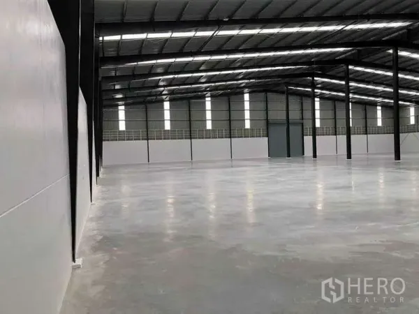 คลังสินค้า ให้เช่าหรือขายในNikhom Phatthana, Rayong - มุมมองด้านข้าง แสดงพื้นคอนกรีตเรียบและแผ่นหลังคากันความร้อน