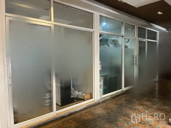 พื้นที่ขายปลีก ให้เช่าในKhlong Toei, Bangkok - ด้านหน้าร้านกระจกฝ้า กรอบอะลูมิเนียมสีขาว ประตูบานเลื่อน พร้อมทางเดินปูกระเบื้องมีหลังคา