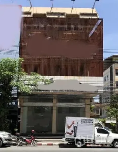 零售空间 出售在Watthana, Bangkok - 位于曼谷Watthana的多层商业楼街景，一层为宽玻璃门面，立面设有竖向格栅。