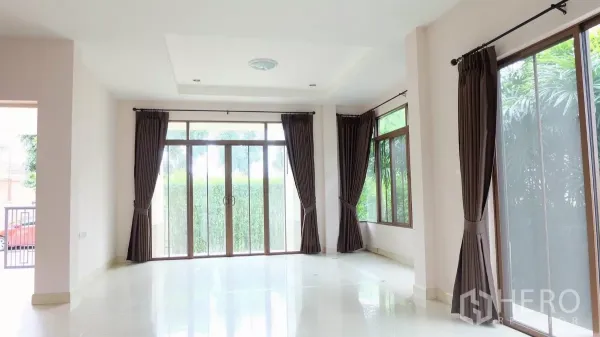 บ้าน ขายในBang Phli, Samut Prakan - ห้องนั่งเล่นสว่าง ประตูกระจกบานเลื่อน หน้าต่างมุม และผ้าม่านสีเข้ม