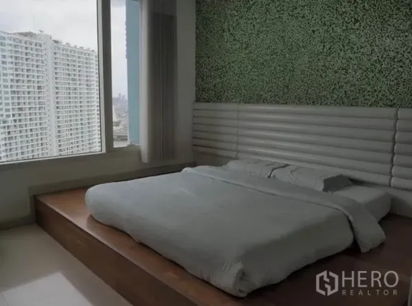 คอนโด ให้เช่าในKhlong San, Bangkok - ห้องนอนเตียงยกพื้น หน้าต่างบานใหญ่ ผนังตกแต่งสีเขียว มองเห็นวิวตึกสูง