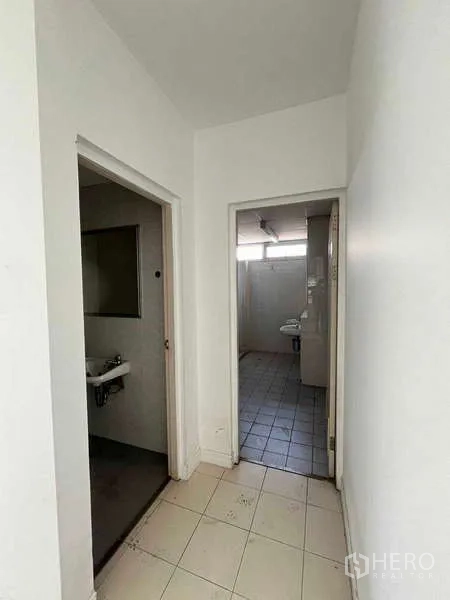 货栈 出租在Lat Krabang, Bangkok - 通往卫生间的过道，地面铺砖的工业办公区。