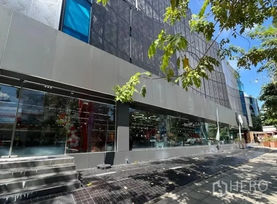 展厅 出租在Bang Rak, Bangkok - 是隆–沙吞CBD街层临街玻璃展示厅外观，落地窗与树荫人行道。
