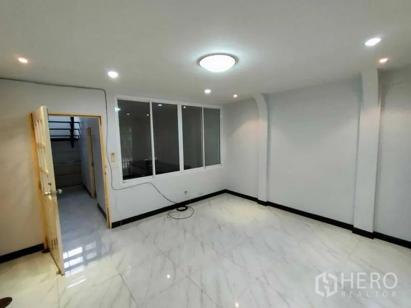 ทาวน์เฮาส์ ให้เช่าในKhlong Toei, Bangkok - พื้นที่นั่งเล่นอีกส่วน พื้นเงางาม เพดานติดไฟ และผนังกระจกกั้นห้อง