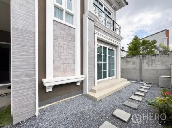 独立式住宅 出租在Chom Thong, Bangkok - 房屋侧院铺碎石小花园，踏步石与大推拉落地门。