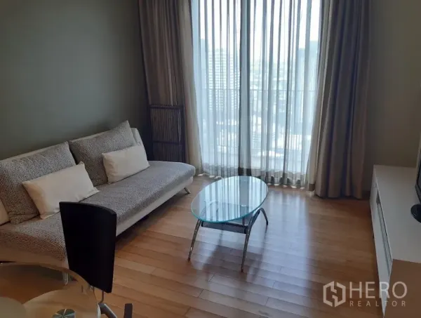 คอนโด ให้เช่าในKhlong Toei, Bangkok - ห้องนั่งเล่นสว่างด้วยหน้าต่างแบบเต็มบาน มีโซฟา โต๊ะกลางกระจก และประตูกระจกออกระเบียง