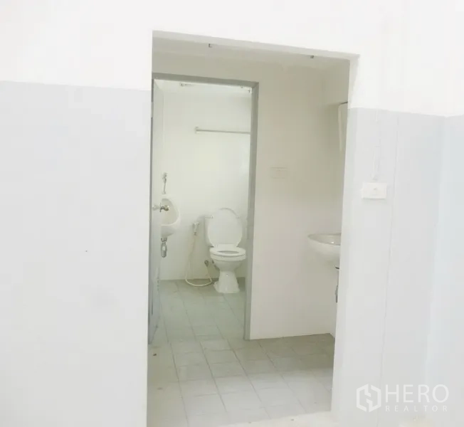 工厂 出租或出售在Pathum Thani - 厂内整洁的卫生间，配马桶、小便池与洗手盆，地面铺砖。