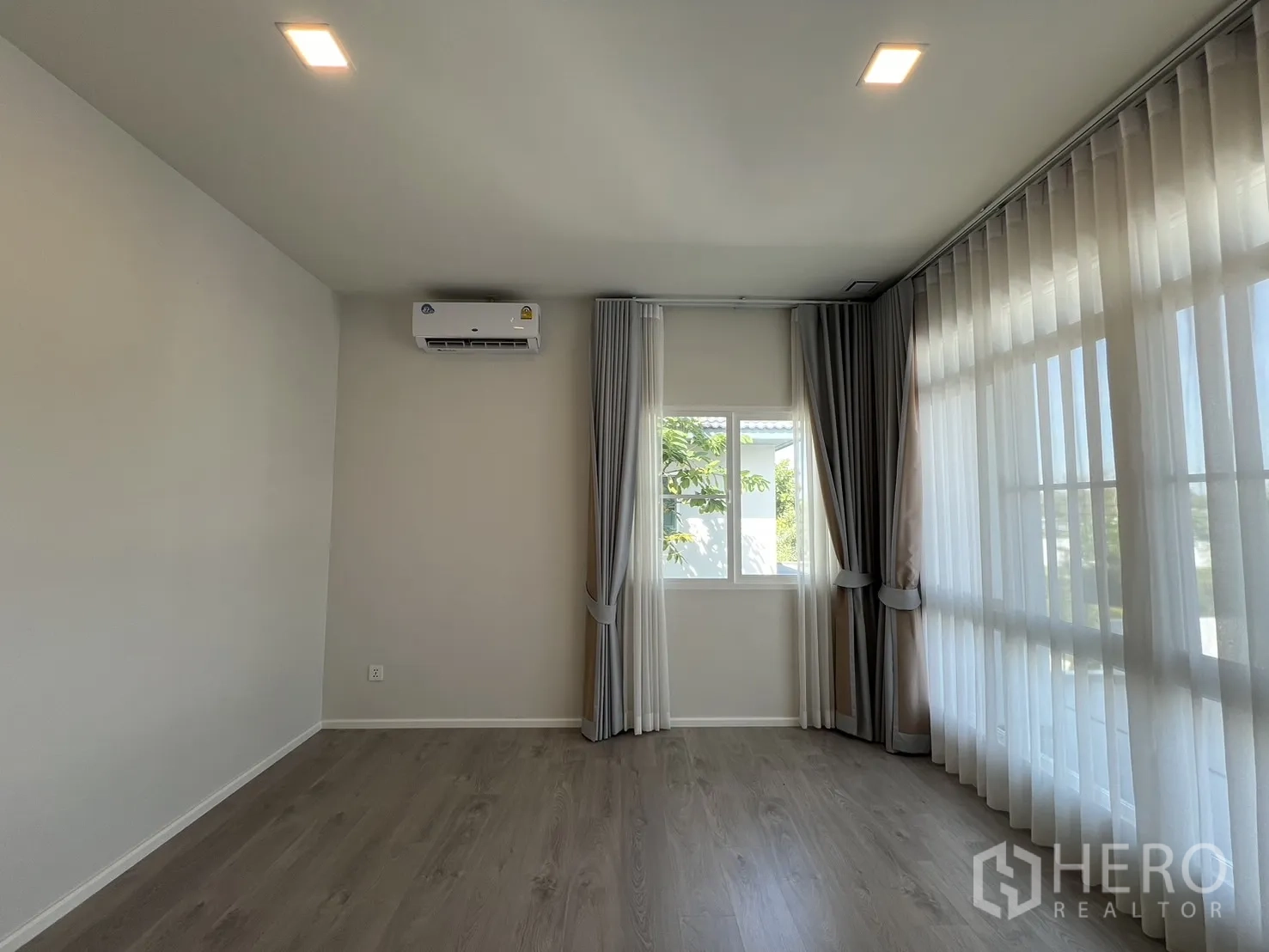 独立式住宅 出租在Prawet, Bangkok - 转角卧室，三面窗与分层窗帘。