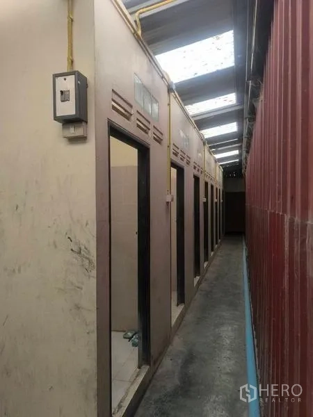 Warehouse for rent in Lat Lum Kaeo, Pathum Thani - Row of restrooms along a corridor with utility lines in an industrial facility.