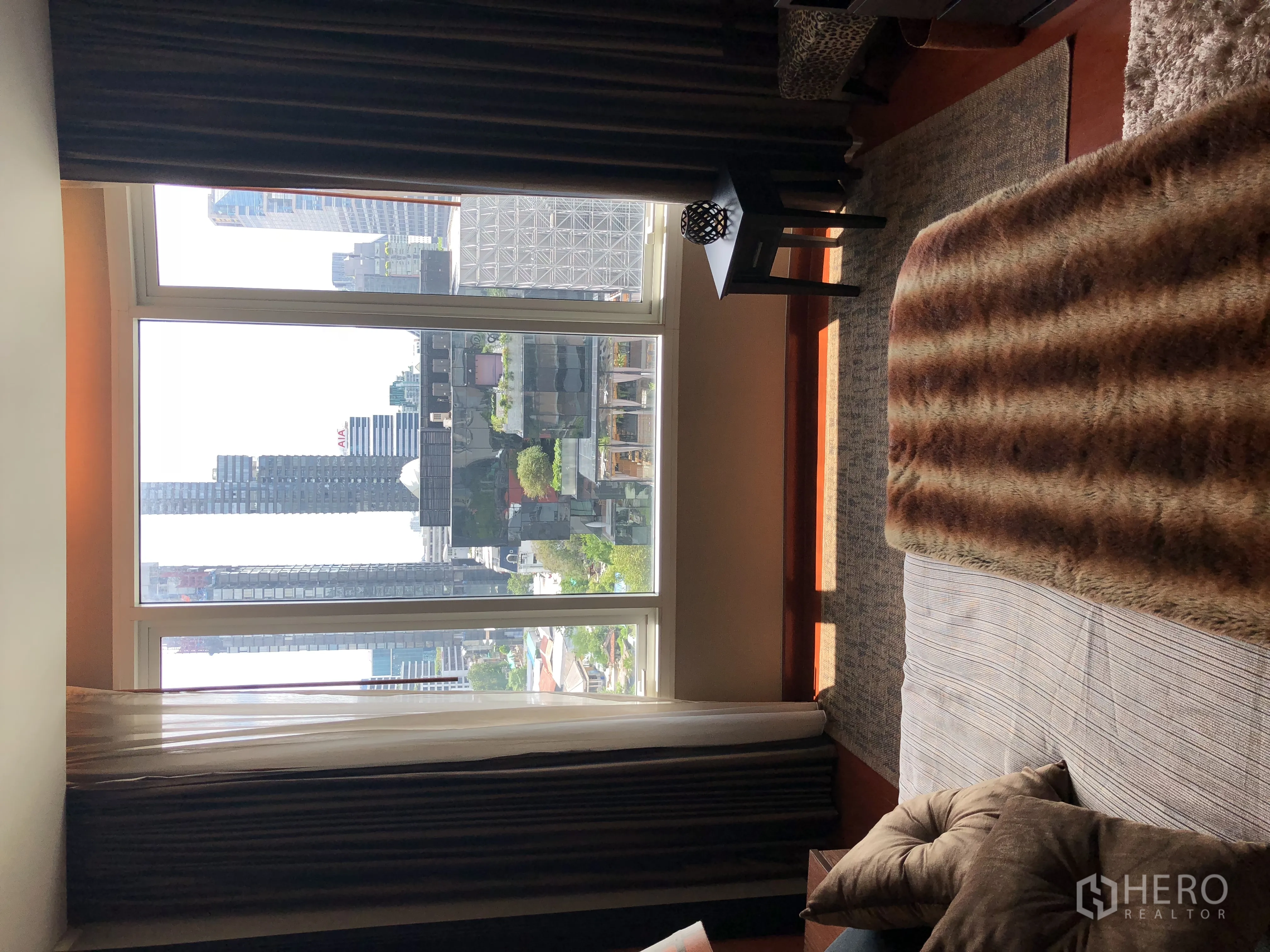 Condominium for rent in Bang Rak, Bangkok - Bedroom with floor-to-ceiling window bringing in natural light and views over the urban skyline.