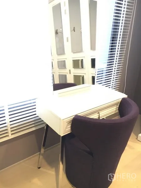 独立式住宅 出租在Wang Thonglang, Bangkok - 采光明亮的梳妆角，白色梳妆台与紫色椅，临近百叶窗。