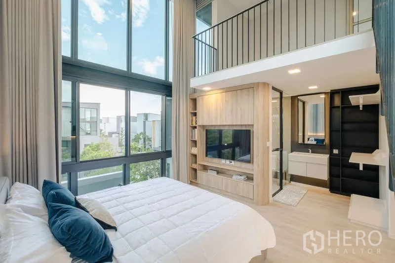 Detached House for rent in Saphan Sung, Bangkok - Bedroom with floor-to-ceiling windows and ensuite beside loft area.