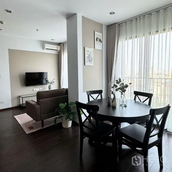 公寓 出租在Watthana, Bangkok - 开放式客餐区另一视角，圆桌、沙发与转角窗