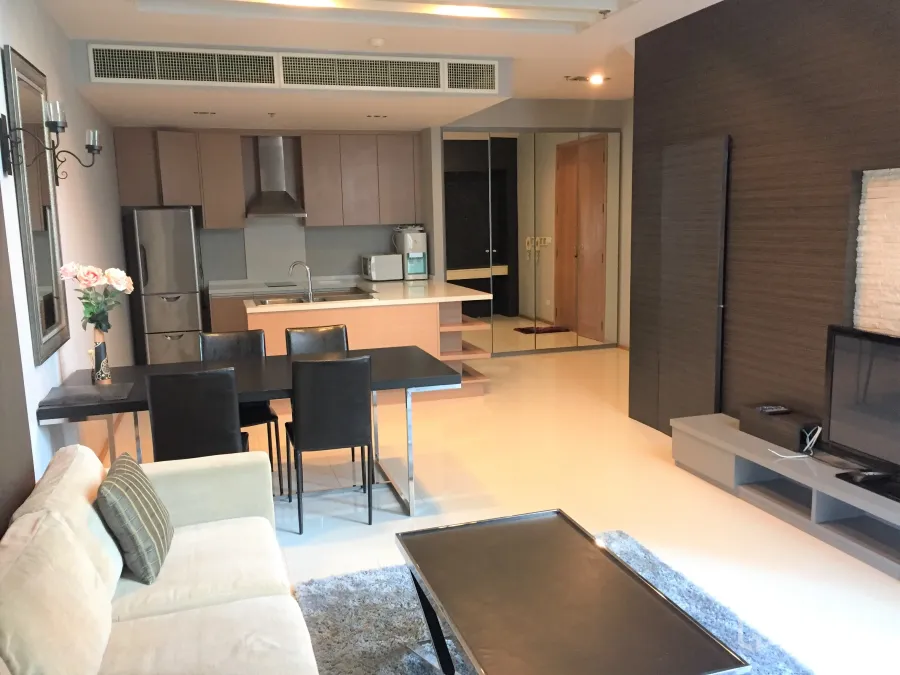 คอนโด ให้เช่าในKhlong Toei, Bangkok - ห้องนั่งเล่นแบบเปิดโล่ง โซฟาสีเบจ โต๊ะทานอาหาร ชั้นวางทีวี และครัวโมเดิร์นพร้อมไอแลนด์และเครื่องใช้สแตนเลส
