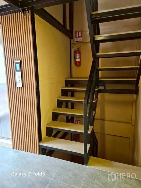 พื้นที่ขายปลีก ให้เช่า - บันไดเหล็กข้างลิฟต์ พร้อมถังดับเพลิงในพื้นที่ส่วนกลาง