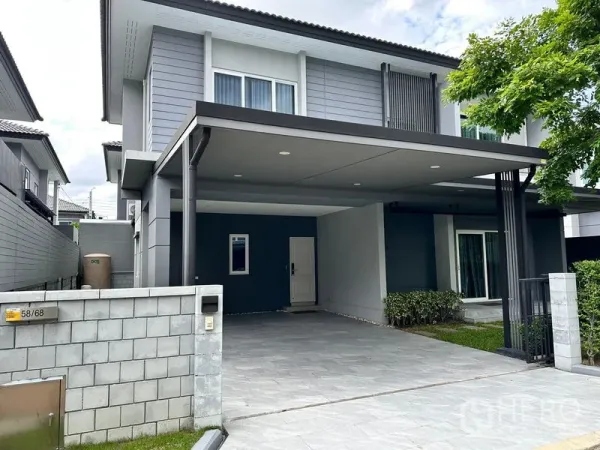 独立式住宅 出售在Prawet, Bangkok - 房屋正立面，宽大的有顶车棚、滑门与现代外墙。