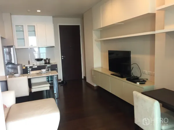 คอนโด ให้เช่าในWatthana, Bangkok - พื้นที่นั่งเล่นแบบโอเพ่นพร้อมชั้นวางทีวี ชั้นเก็บของ ชุดโต๊ะทานข้าว และครัวขนาดกะทัดรัดในคอนโดทองหล่อ