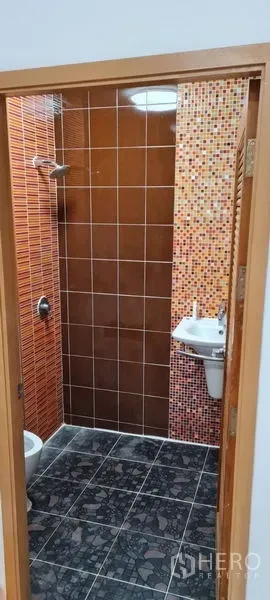 Townhouse for rent in Watthana, Bangkok - Compact bathroom with orange and mosaic wall tiles and a walk-in shower.