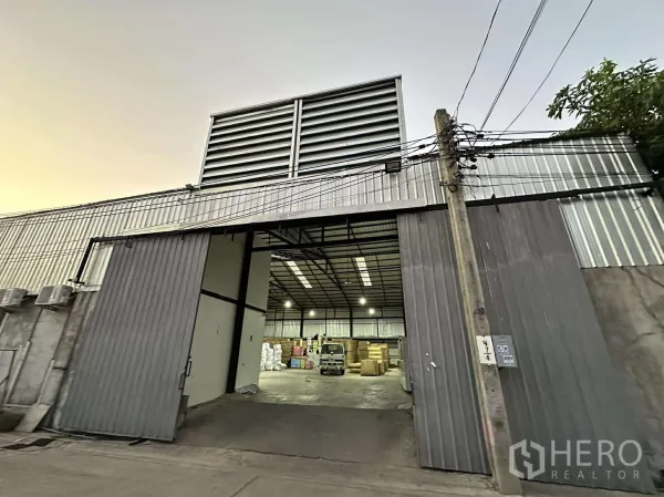 货栈 出租 - 仓库大门敞开，可见明亮的装卸区与室内空间。