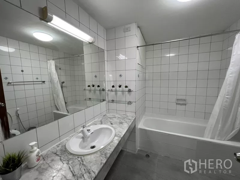 ทาวน์เฮาส์ ให้เช่าหรือขายในSuan Luang, Bangkok - ห้องน้ำกระเบื้องสีขาว เคาน์เตอร์หินอ่อน พร้อมอ่างอาบน้ำมีผ้าม่าน