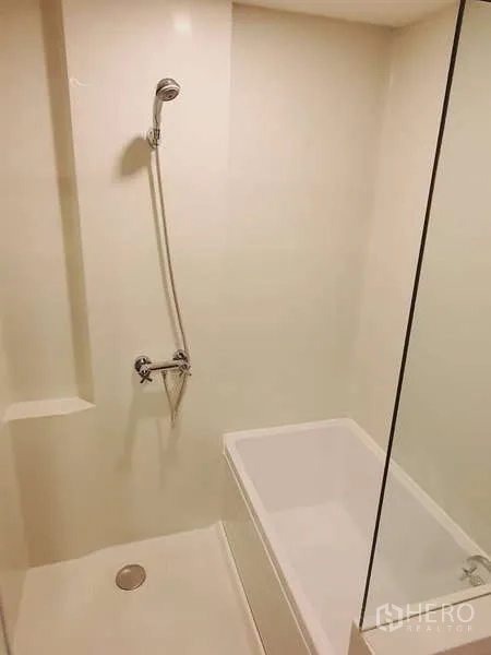 Condominium for rent in Sathon, Bangkok - Modern bathroom with glass shower and separate soaking tub in neutral tones.