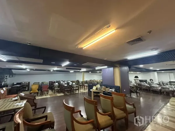 零售空间 出租 - 宽阔的零售楼层，座椅展示，吊顶与暖色照明。