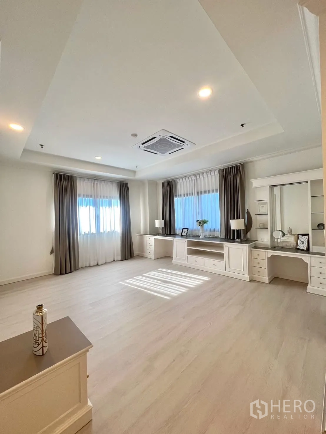 Condominium for rent in Khlong Toei, Bangkok - Expansive bedroom with built-in TV console, desks and wide windows.