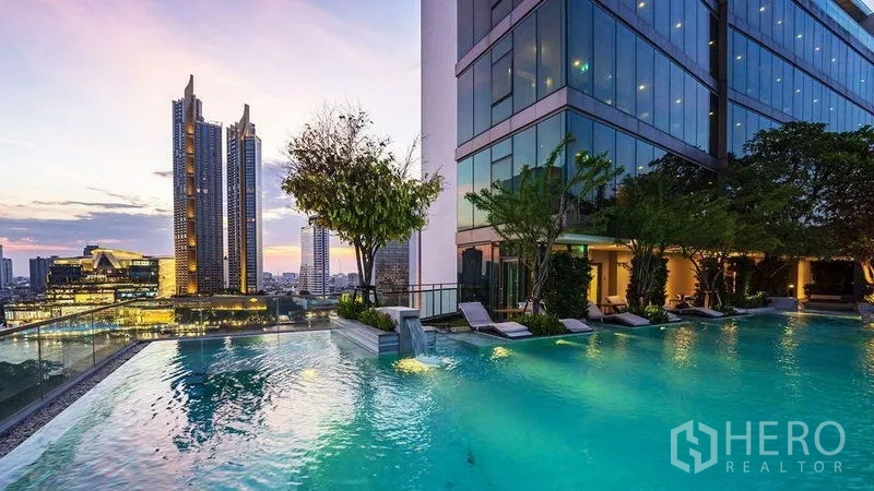 公寓 出售在Bang Rak, Bangkok - 公寓无边际泳池，黄昏时分的城市天际线景观。