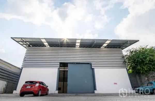 คลังสินค้า ให้เช่าในMueang Samut Prakan, Samut Prakan - ด้านหน้าโกดังสมัยใหม่ ประตูบานเลื่อนขนาดใหญ่ ผนังเมทัลชีท ลานจอดรถและทางเข้าออกกว้าง