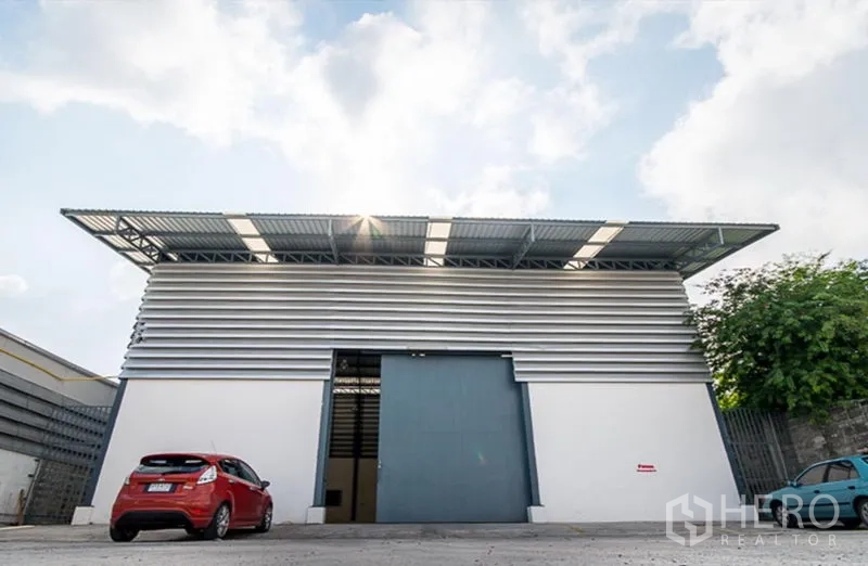 คลังสินค้า ให้เช่าในMueang Samut Prakan, Samut Prakan - ด้านหน้าโกดังสมัยใหม่ ประตูบานเลื่อนขนาดใหญ่ ผนังเมทัลชีท ลานจอดรถและทางเข้าออกกว้าง