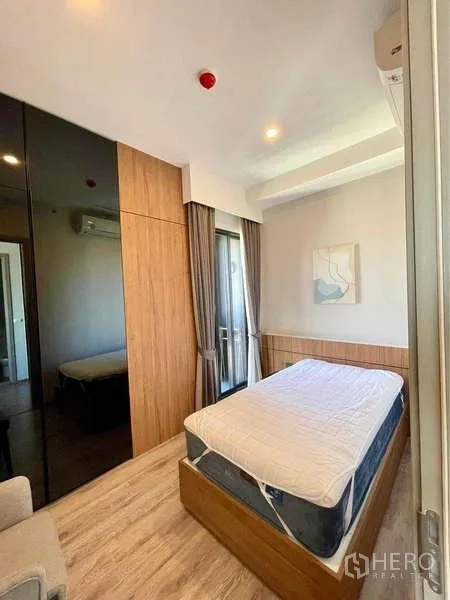 公寓 出租在Watthana, Bangkok - 次卧配床与木质衣柜，窗帘及可通向小阳台的推拉玻璃门。