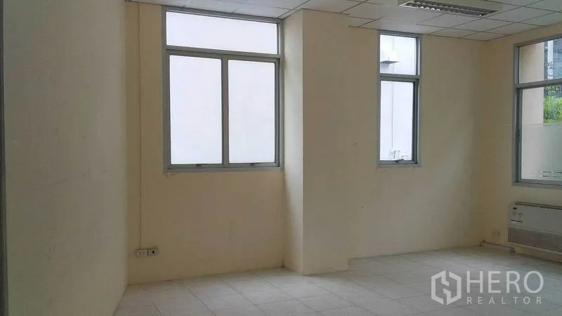 สำนักงาน ให้เช่าในPhra Khanong, Bangkok - มุมสำนักงานมีหน้าต่างหลายบาน ผนังสีอ่อน และฝ้าหลุมพร้อมไฟ