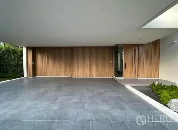 Detached House for rent - Covered carport with gray tile floor, wood slat feature wall and entry door.