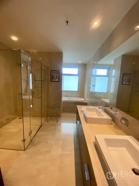 公寓 出租在Watthana, Bangkok - 豪华卫浴，双洗手台、玻璃淋浴间与浴缸，配磨砂窗。