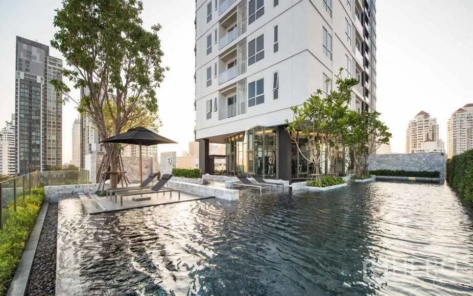 Condominium for rent or sale in Watthana, Bangkok - Rooftop swimming pool beside a modern condominium with city skyline views in Thonglor.