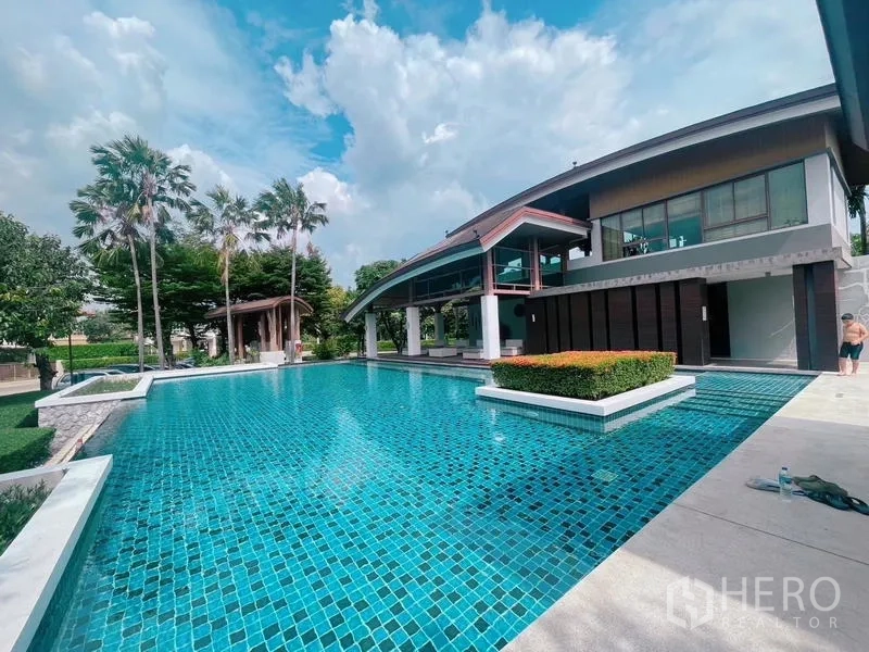 Detached House for rent in Prawet, Bangkok - Large communal swimming pool and clubhouse surrounded by trees.