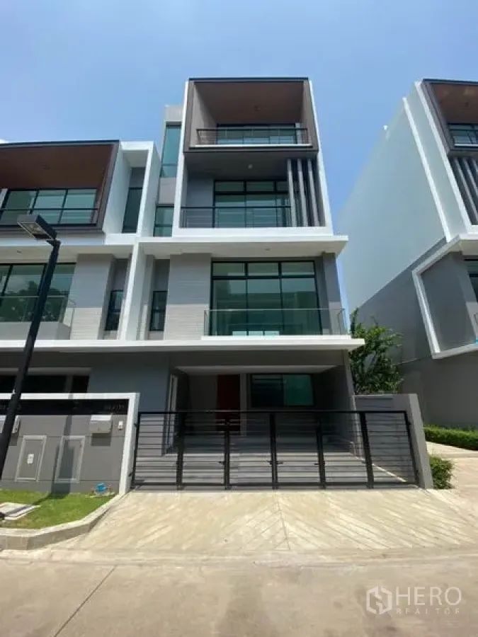 Townhouse for rent in Saphan Sung, Bangkok - Modern multi-storey townhouse facade with balconies, full-height glass and gated driveway in Saphan Sung.