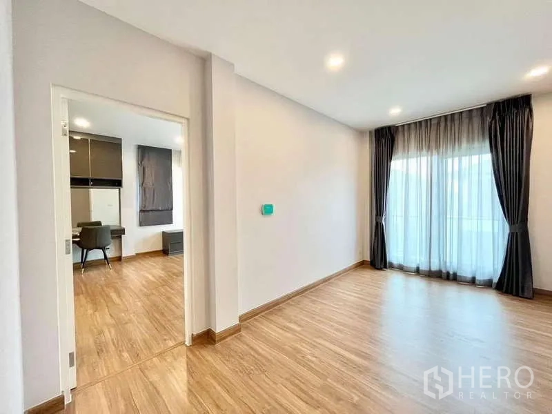 Detached House for rent in Don Mueang, Bangkok - Upstairs family area opening to study room and balcony with sheer curtains.