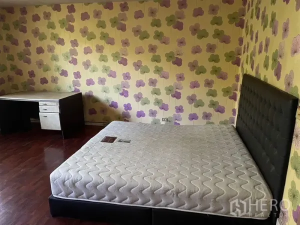 สำนักงานที่บ้าน ให้เช่าในWatthana, Bangkok - ห้องนอนวอลเปเปอร์ลายดอกไม้ พื้นไม้ เตียงบุนวม และโต๊ะทำงานมุมห้อง